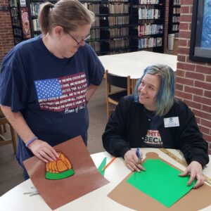 Diane and her daughter, Nikki, putting together the baseball themed bulletin board.
