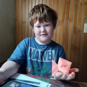 Tishomingo patron Kayden with his craft projects from packet one