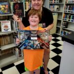 Sarah and her son Kayden at the Tishomingo Library with their chosen reward for reading this summer