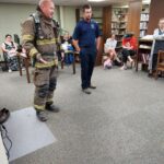 Meryl Williams, Belmont Fire Chief, explaining the gear to the children at Belmont Library Summer Reading Program 🌞 All Together Now!